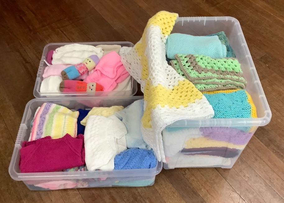Colourful samples of knitting in 3 small plastic storage boxes