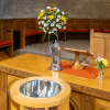 The christening font, jug of water and flowers in the Sanctuary