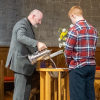 Rev Fergus Cook pours water into the baptism font
