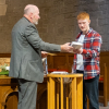 Rev Fergus Cook presents Sam with a Bible and Certificate of Baptism
